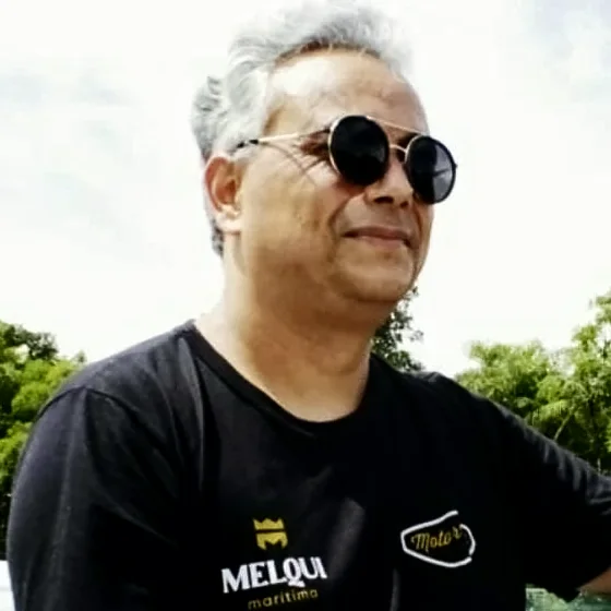 Marcel Segala a bordo de uma embarcação, de óculos escuros